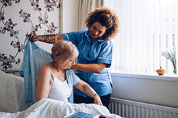 A nurse helping a patient get dressed