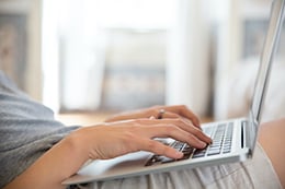A person typing on their laptop